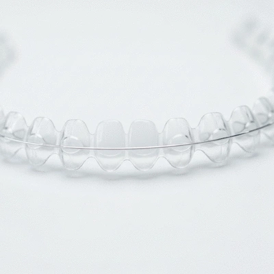 Close-up of clear invisible aligners on a white background, symbolizing discreet orthodontics for adults, no text, no words, no typography, 8K